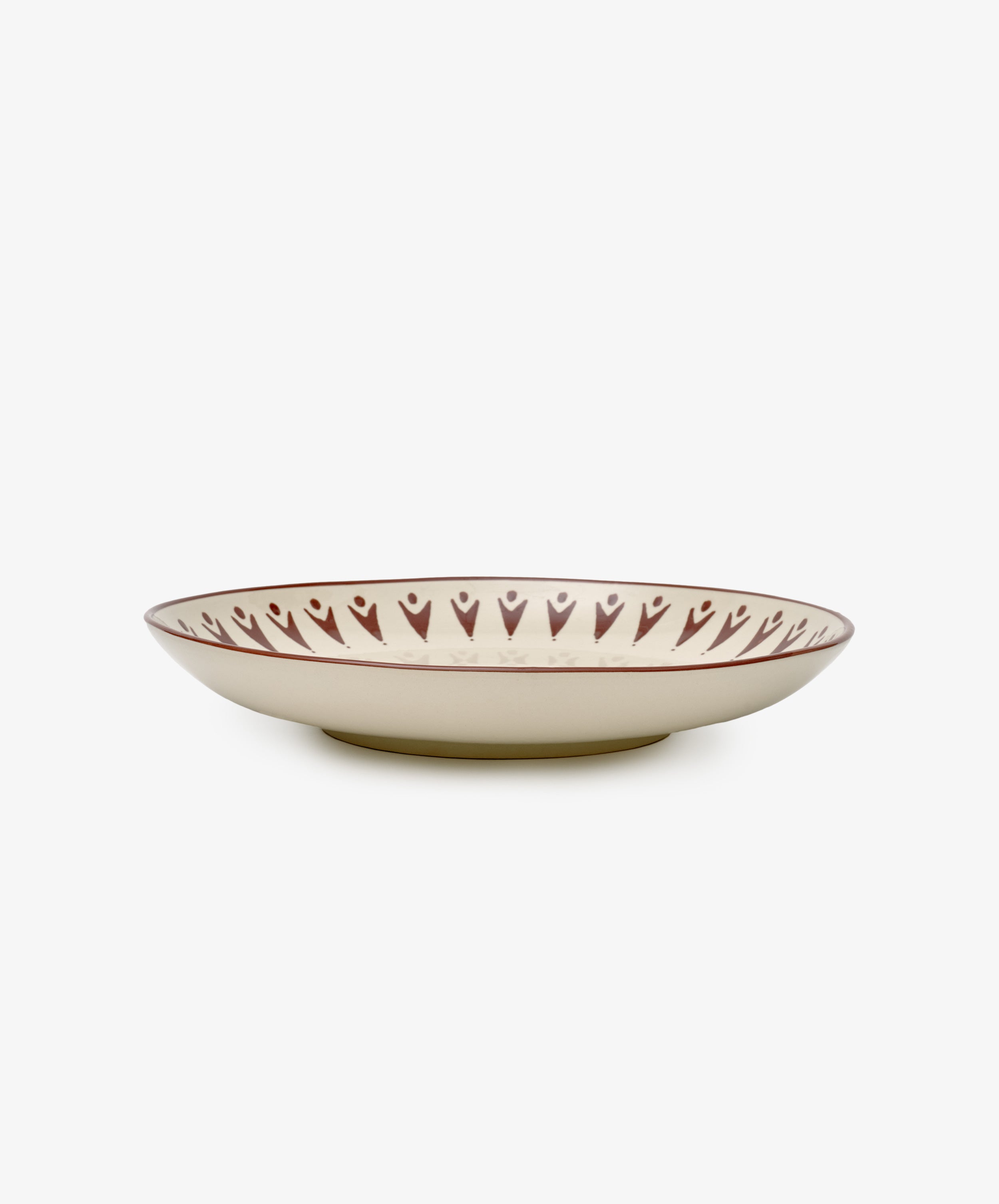 The Vito Serving Platter is a handmade, shallow round ceramic plate featuring a cream base and a brown rim with heart-shaped patterns.