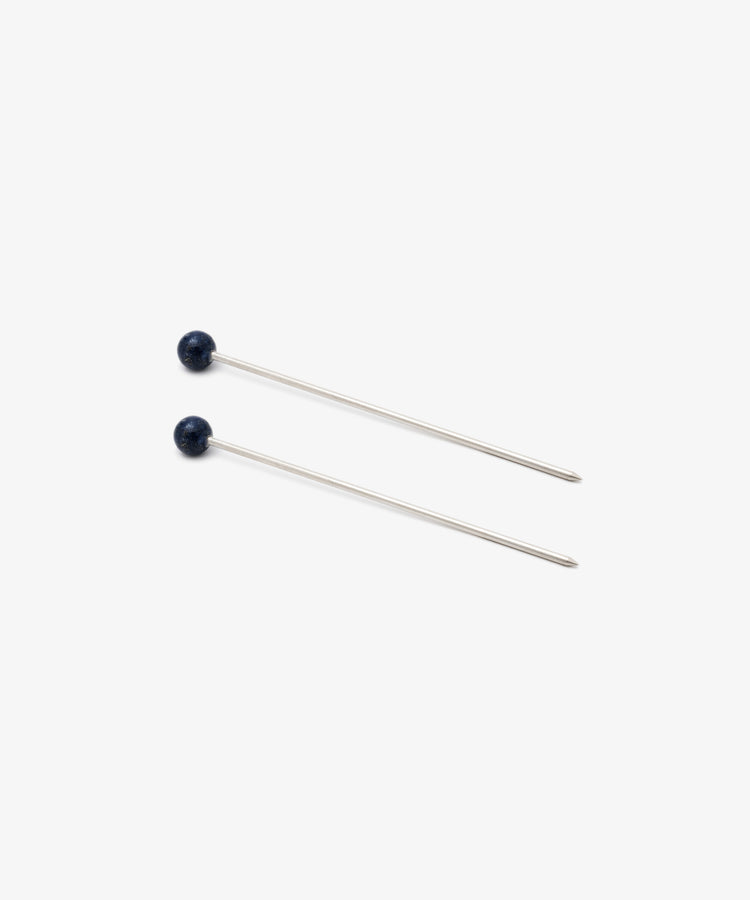 The Ella Cocktail Sticks, Set of 2, features two straight metal pins with small round blue stone heads, arranged parallel on a plain white background.