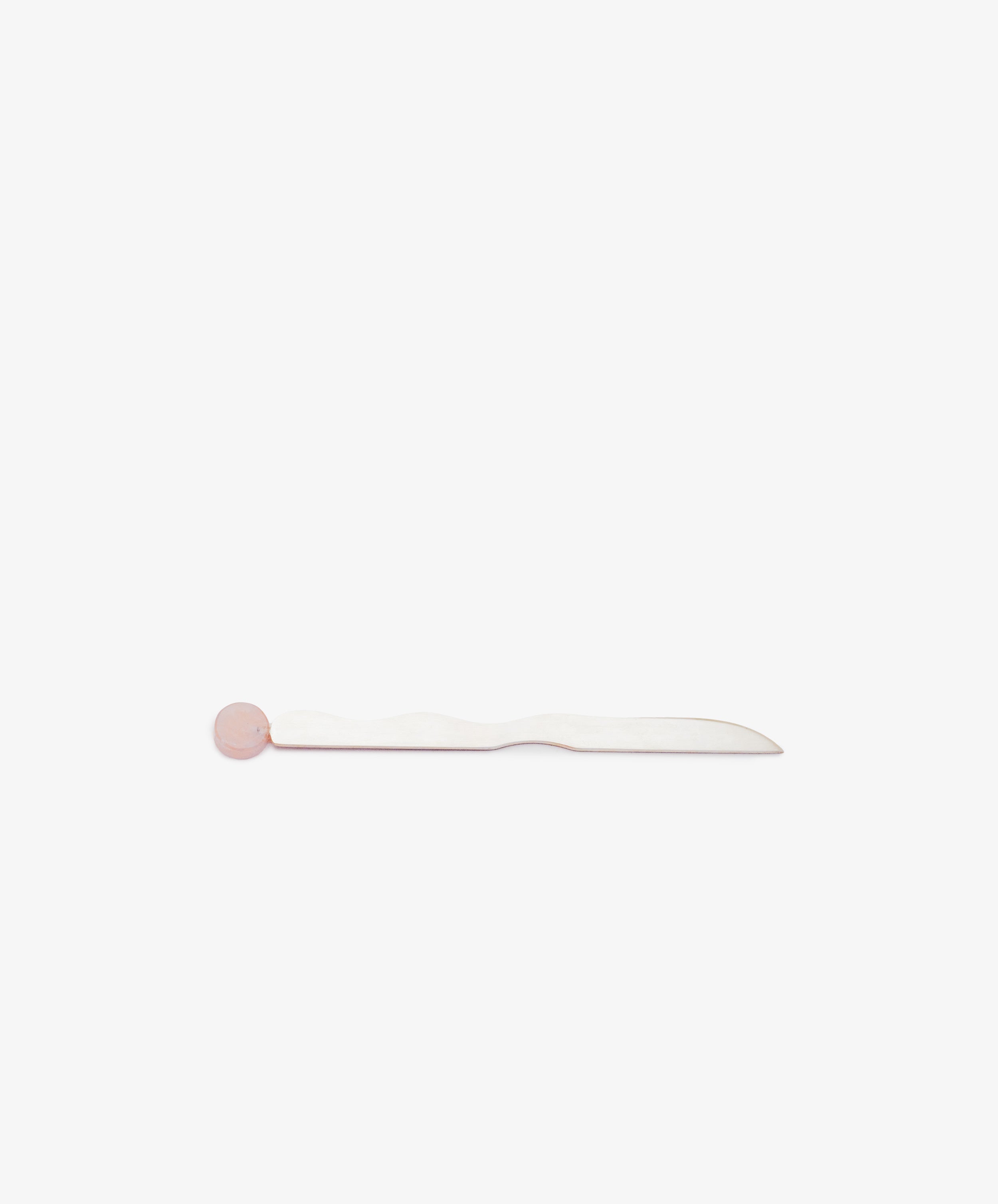 The Letter Opener is a handcrafted desk accessory with a white, slightly wavy handle and a round pink accent at one end, displayed on a plain white background.