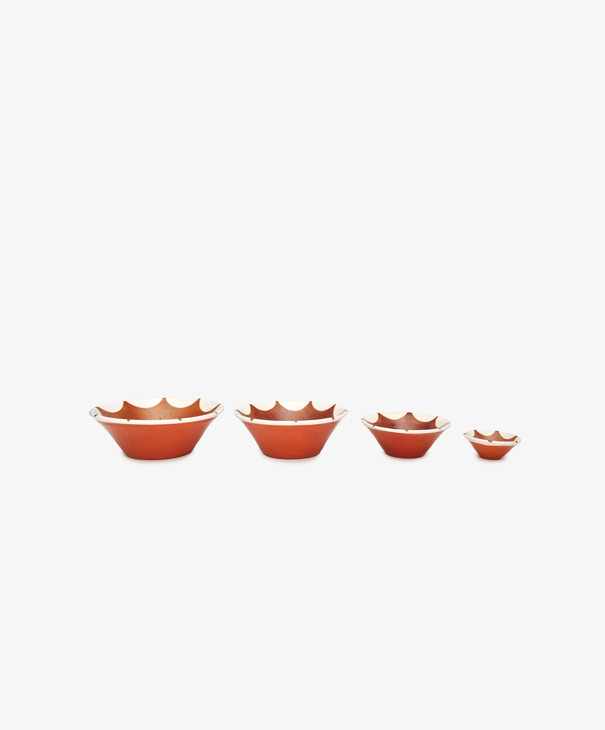 The Stella Nesting Bowls—four handmade terracotta bowls in graduated sizes—are arranged in a row on a white background, ideal for serving aperitivo snacks as mix-and-match pieces.