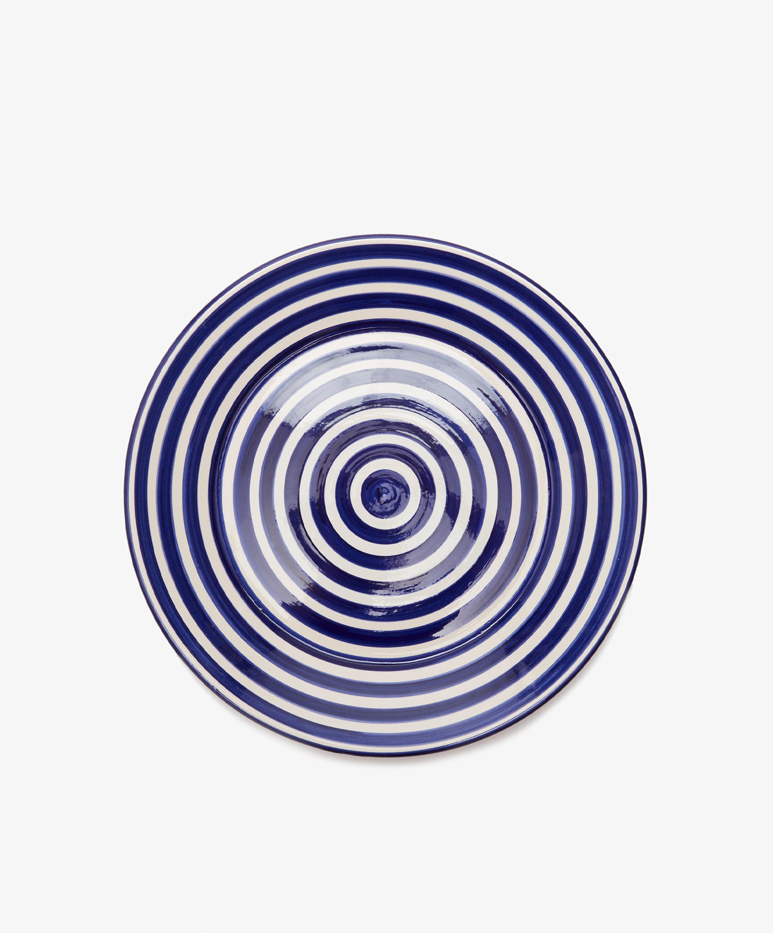 The Natalia Serving Bowl, handcrafted with a white base and navy blue concentric circles, is pictured from above on a plain white background—making it an ideal gift.