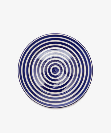 The Natalia Serving Bowl, handcrafted with a white base and navy blue concentric circles, is pictured from above on a plain white background—making it an ideal gift.