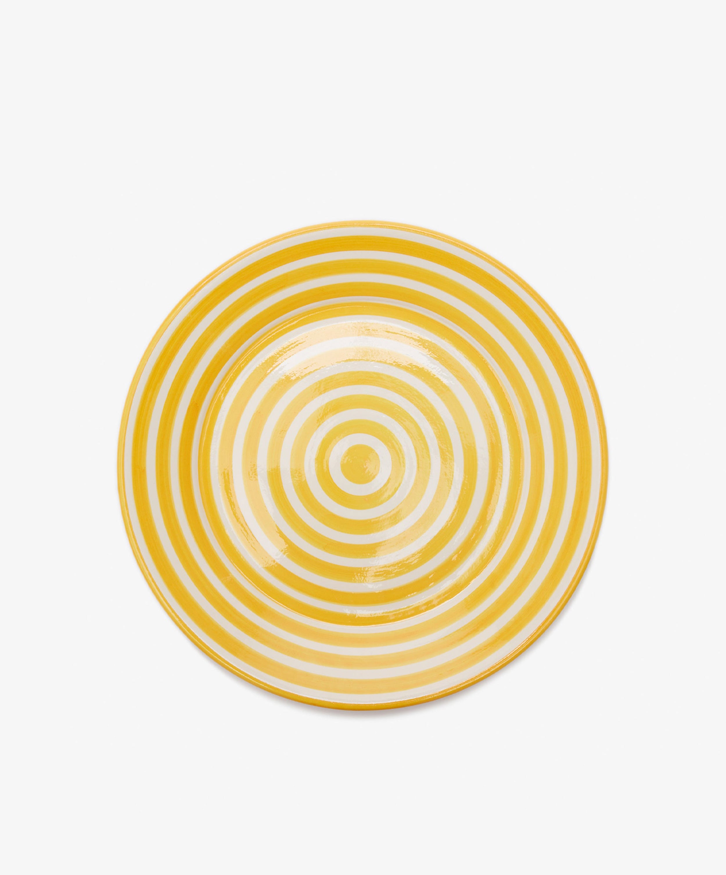 The Natalia Serving Bowl features a unique design of concentric yellow and white circles on a plain white background.