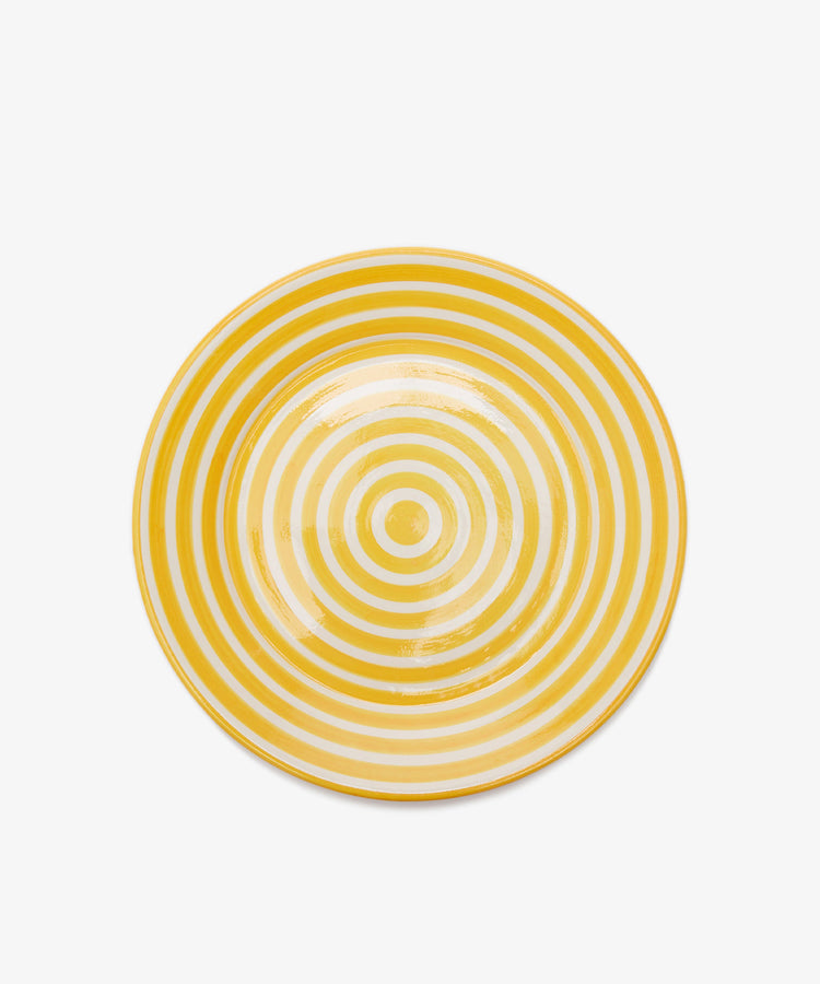 The Natalia Serving Bowl features a unique design of concentric yellow and white circles on a plain white background.