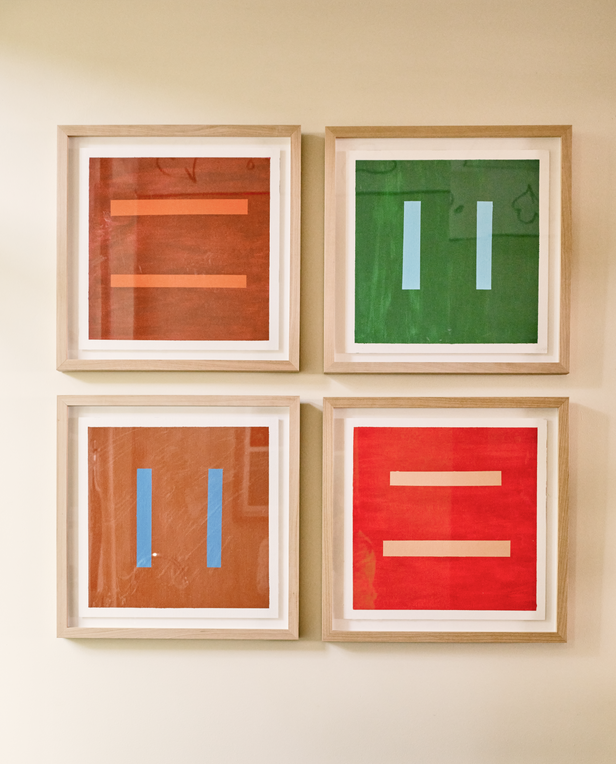 Four framed abstract artworks with bold colored backgrounds and simple vertical or horizontal bars