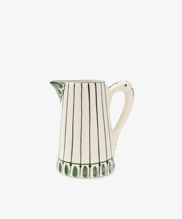 The Jorge Jug is a green-and-white ceramic pitcher with vertical green lines, a flared spout, and a curved handle. Inspired by the classic Portuguese jug and its traditional pattern, it's shown on a plain white background.