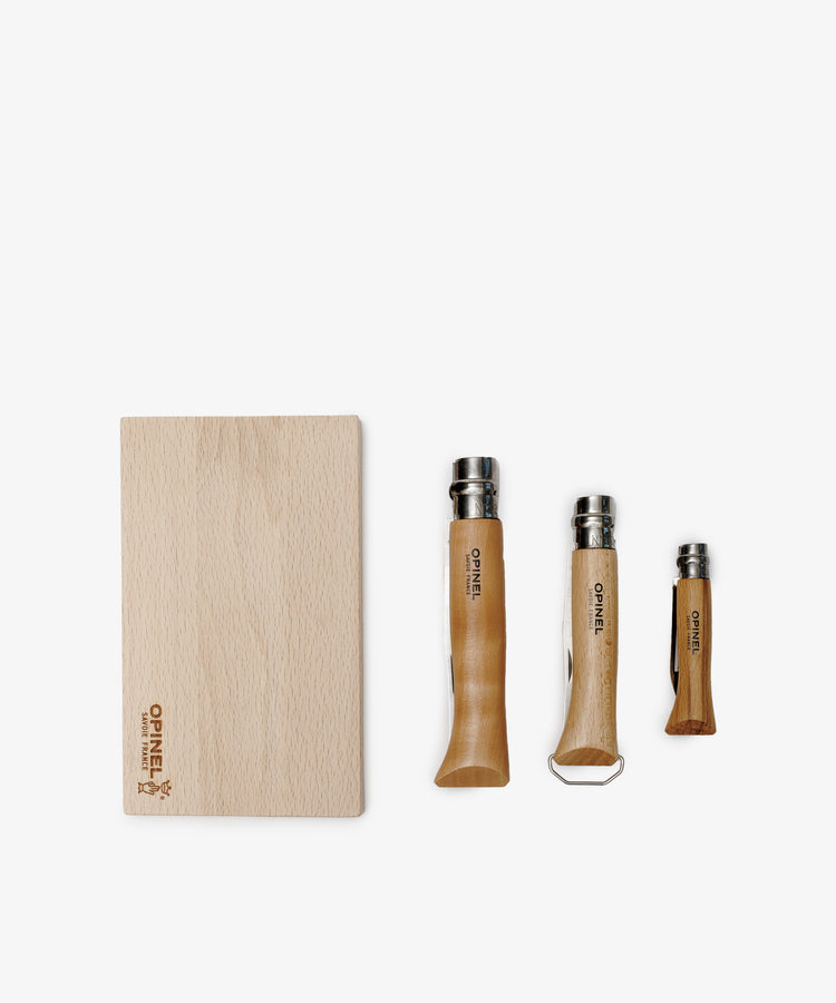The Nomad Kit with Bottle Opener Knife features a wooden cutting board and three Opinel knives in different sizes—ideal for your travel kitchen kit or as a portable picnic utensil set.