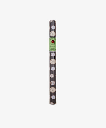 A roll of Intaglio Gift Wrap featuring black paper with circular white designs and a green label reading CARTI at the top center, perfect for presenting Grand Tour gifts in style.