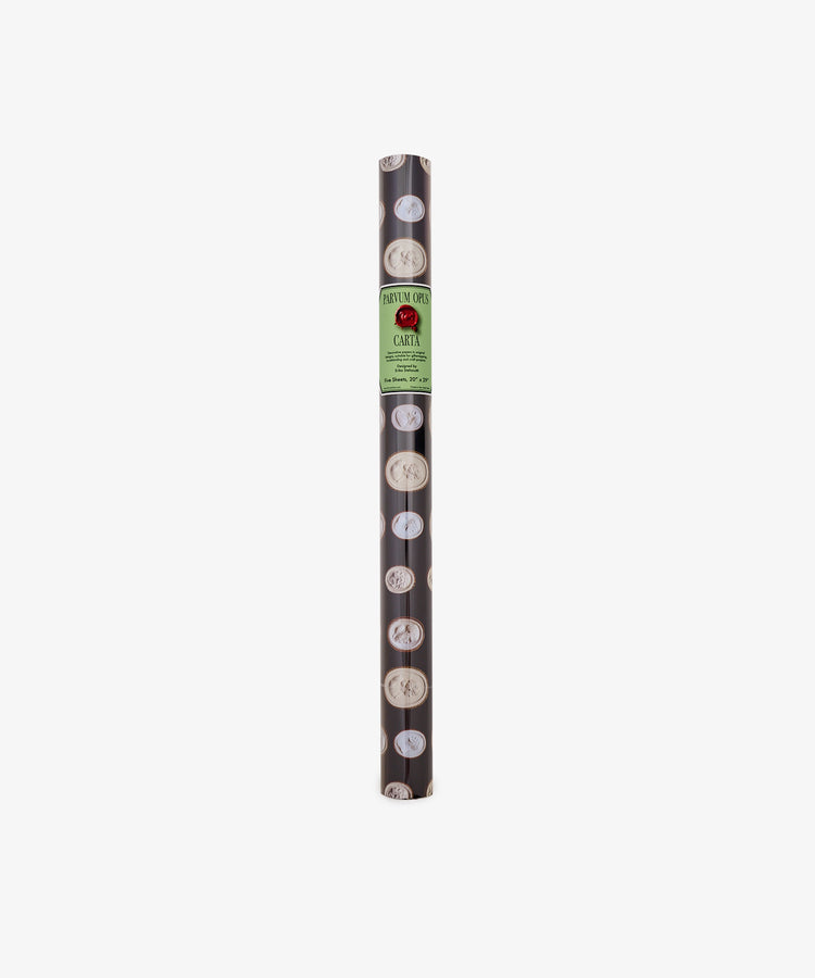 A roll of Intaglio Gift Wrap featuring black paper with circular white designs and a green label reading CARTI at the top center, perfect for presenting Grand Tour gifts in style.