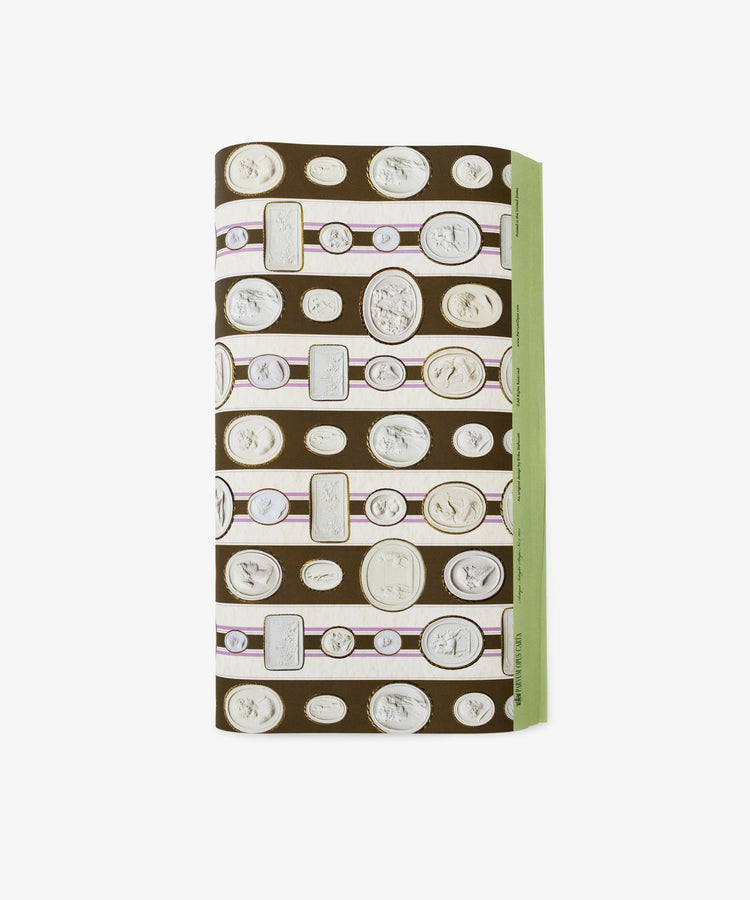 A folded rectangular Intaglio Stripe Gift Wrap featuring classical coin and cameo designs on a brown background with a green edge—perfect for neoclassical gifts from Parvum Opus.