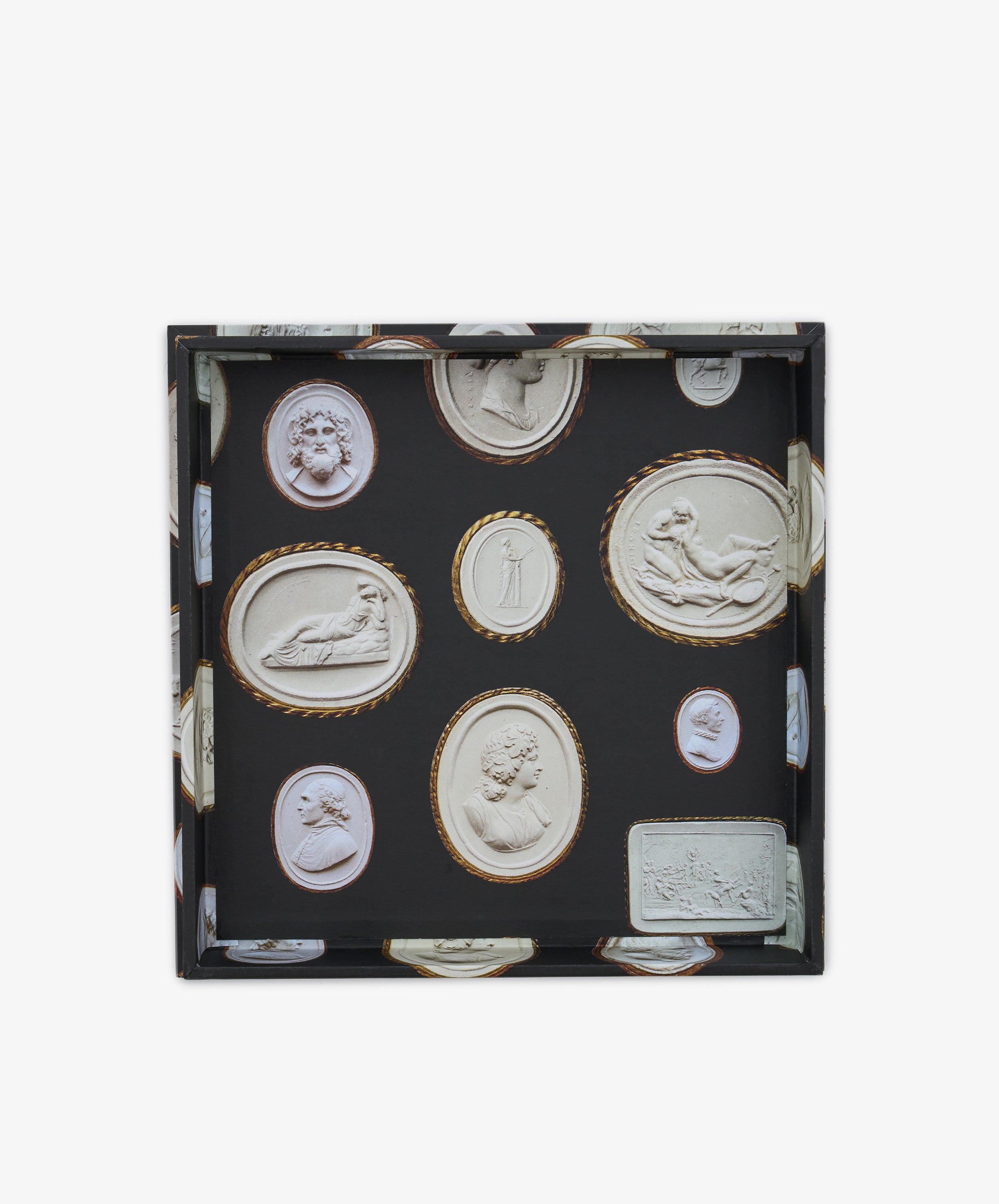 The Intaglio Nesting Tray is a square tray with a black background, showcasing finely detailed classical carved cameo and cameo-style relief designs in white and gold tones. Crafted from archival book board, this elegant scholar desk accessory combines refined artistry with functional sophistication.