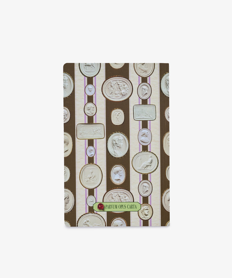 The Intaglio Notebook features a soft brown cover adorned with vertical stripes and white cameo-style medallion motifs. A green label on the front reads “PARVUM OPUS CARTA,” while its acid-free writing paper makes it ideal for preserving your notes and sketches.