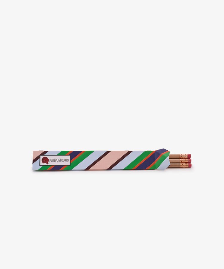 The Pencil Kit includes three American-made pencils with pink erasers, presented in a diagonally striped paper sleeve featuring red, green, blue, black, and tan accents on a white background.