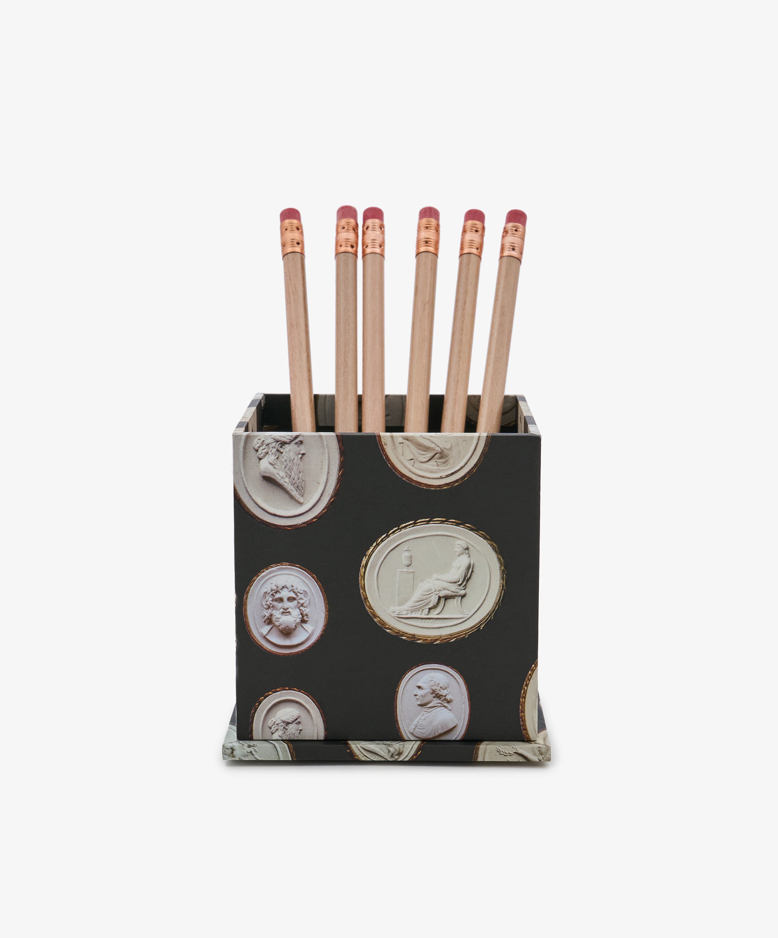 The Intaglio Pencil Pot, featuring classical carved designs in black, holds six wooden pencils with pink erasers, displayed against a white background.