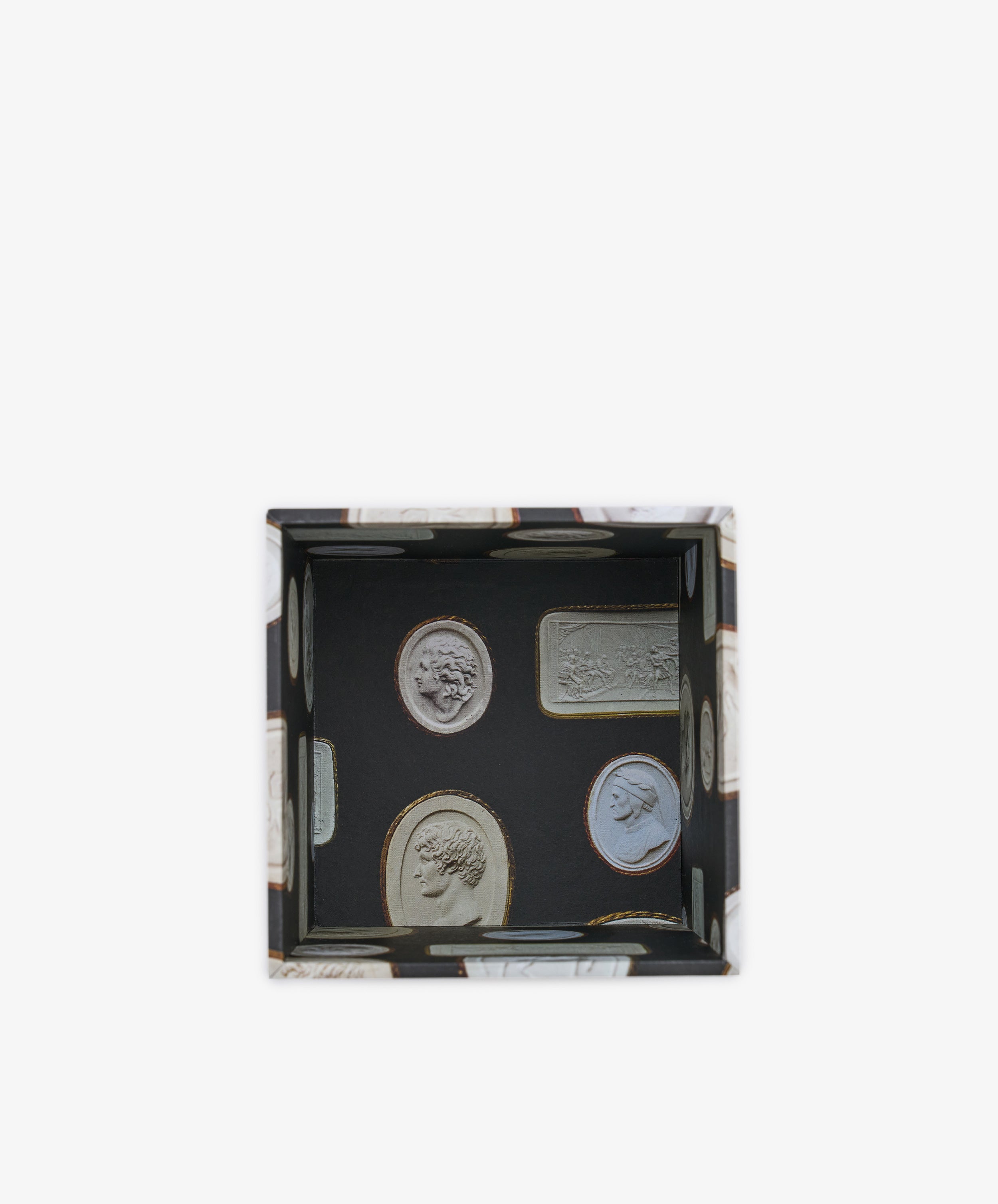 Introducing the Intaglio Pencil Pot—a rectangular desk organizer with a black base, adorned with detailed images of ancient coins and metal bars. This weighted pencil pot features raised edges and a glossy finish, combining functionality and decorative appeal for your workspace.