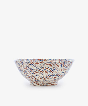 The Celine Salad Bowl is a ceramic salad bowl with a wide rim, showcasing an intricate floral pattern in blue, orange, and beige tones against a white background, beautifully reminiscent of marbled ceramic Agateware.