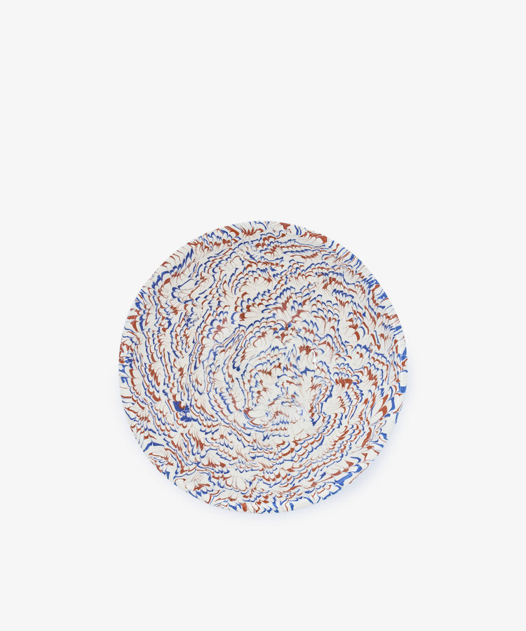 A round marbled ceramic Celine Salad Bowl featuring a swirling abstract pattern in blue, orange, and white on a plain white background.