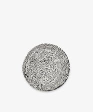 The Celine Serving Plate is a round ceramic piece, handcrafted with a striking black and white abstract, feather-like pattern reminiscent of classic Aptware designs, set against a plain white background.