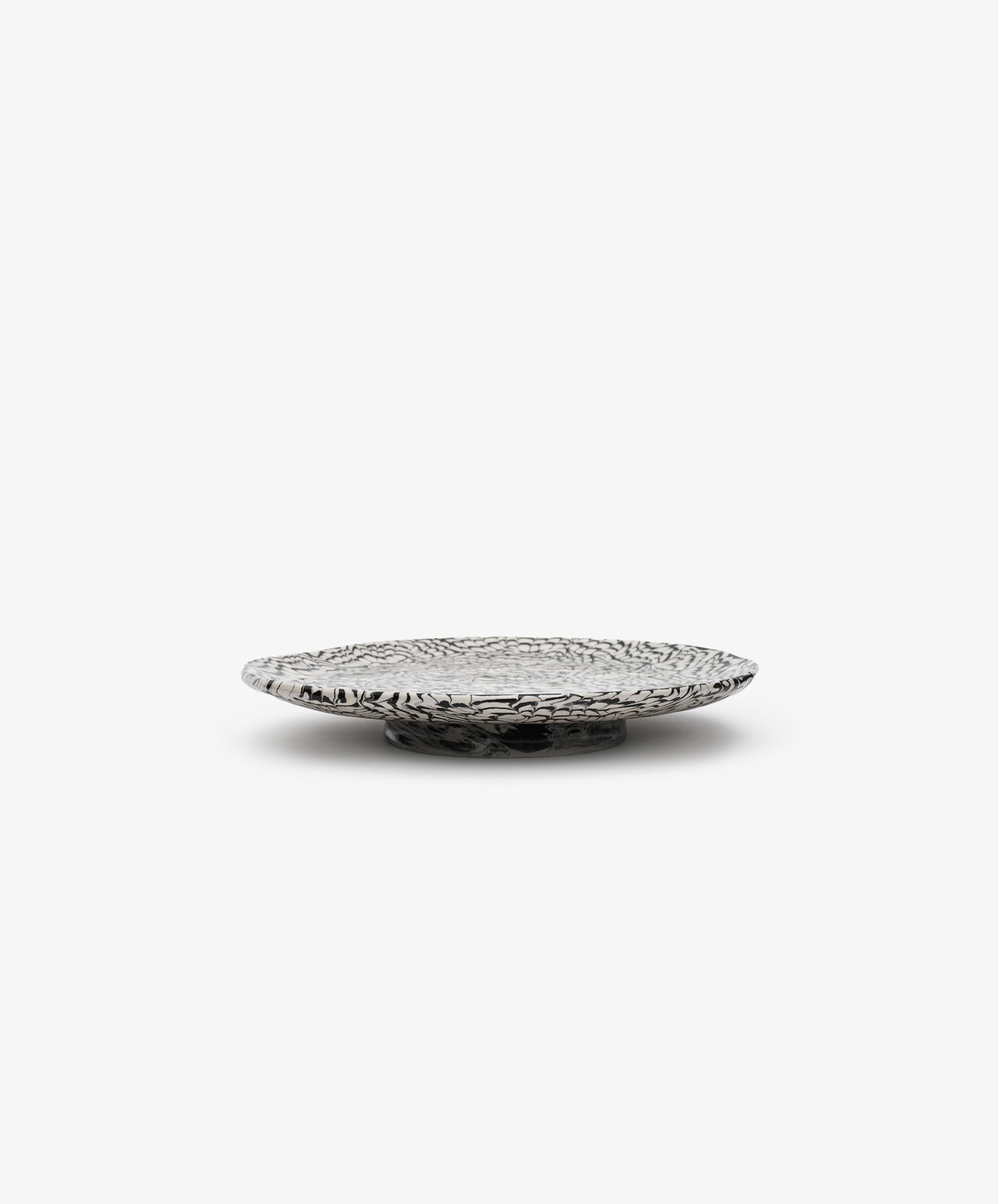 The Celine Serving Plate, a low, round, handcrafted silver dish with a textured, patterned surface, sits on a plain white background.