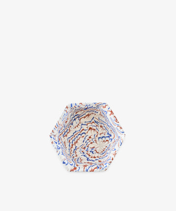 Introducing the Celine Snack Bowl: a hexagonal marbled ceramic bowl featuring a striking pattern in blue, red, and white on a crisp white background—perfect as an aperitivo bowl for serving small bites or as a unique Agateware accent for your table.