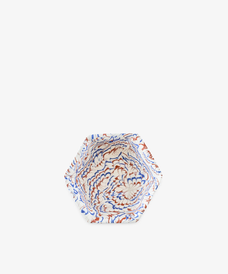 Introducing the Celine Snack Bowl: a hexagonal marbled ceramic bowl featuring a striking pattern in blue, red, and white on a crisp white background—perfect as an aperitivo bowl for serving small bites or as a unique Agateware accent for your table.