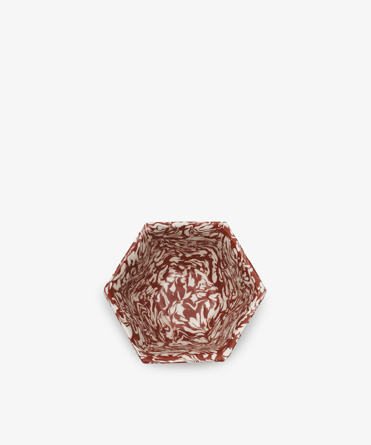 The Celine Snack Bowl features a hexagonal shape and a marbled red and white pattern, shown from above on a plain white background.