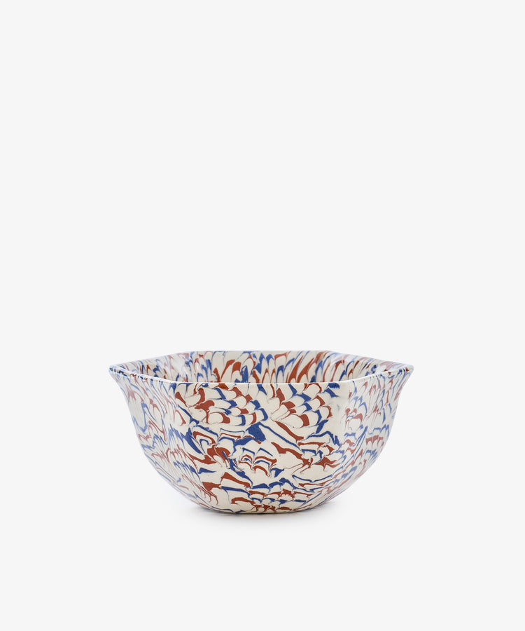 The Celine Snack Bowl showcases an intricate marbled wave pattern in blue, red, and brown on a white background, presented against a plain white surface.