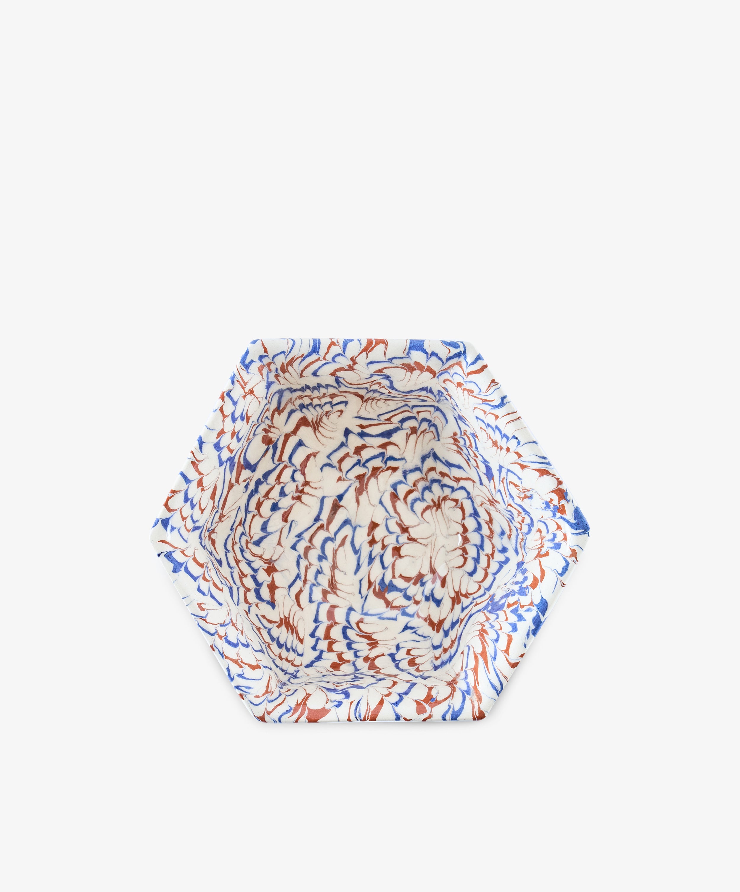 The Celine Snack Bowl is a hexagonal marbled clay piece featuring a swirling blue, brown, and white pattern, shown from above on a plain white background.