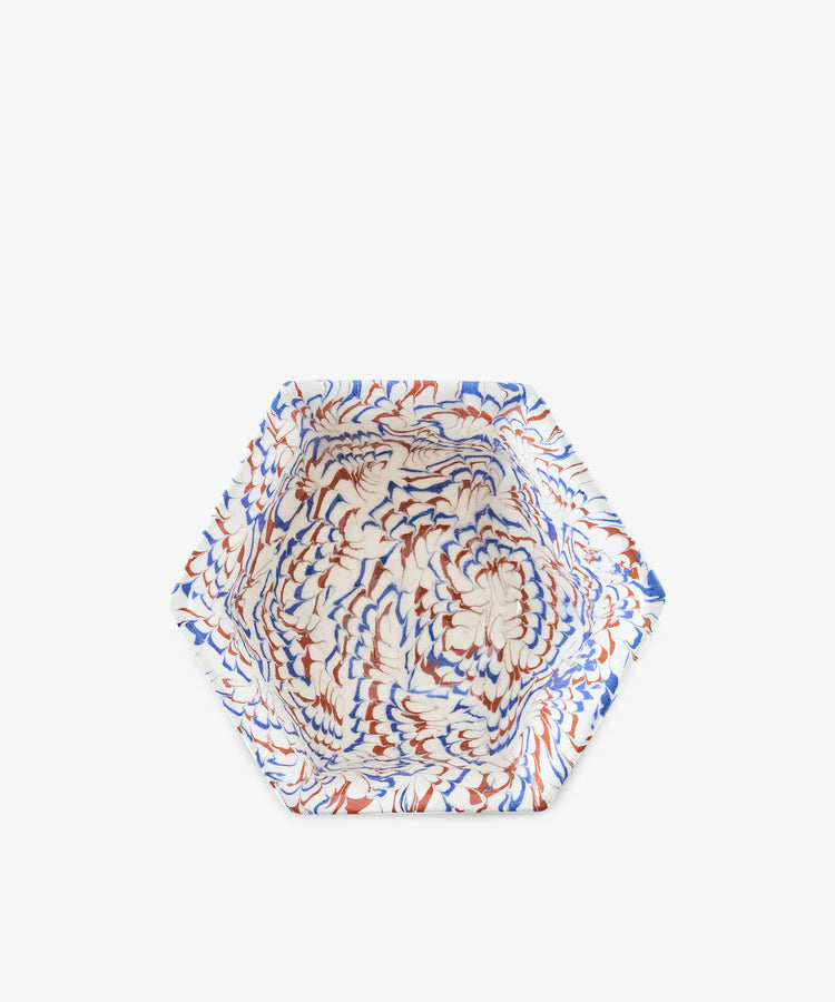 The Celine Snack Bowl is a hexagonal marbled clay piece featuring a swirling blue, brown, and white pattern, shown from above on a plain white background.