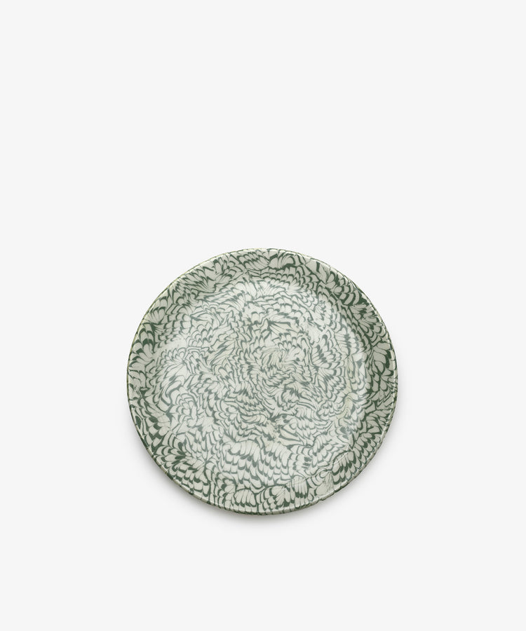 The Celine Serving Plate is a round, handcrafted ceramic platter featuring an intricate green and white floral pattern, beautifully photographed against a plain white background.