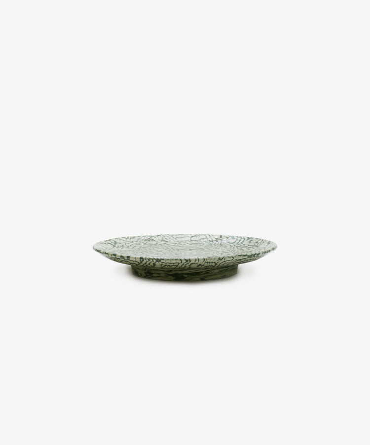 The Celine Serving Plate is a shallow, round ceramic dish featuring a green and white marbled leaf pattern, displayed against a plain white background.