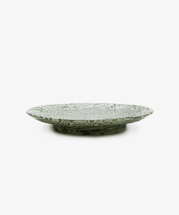 The Celine Serving Platter is a green and white ceramic plate featuring a leaf-like pattern and shown from the side on a plain white background; this handmade serving dish captures the allure of marbled ceramics, making it an elegant Aptware-inspired addition to any table setting.