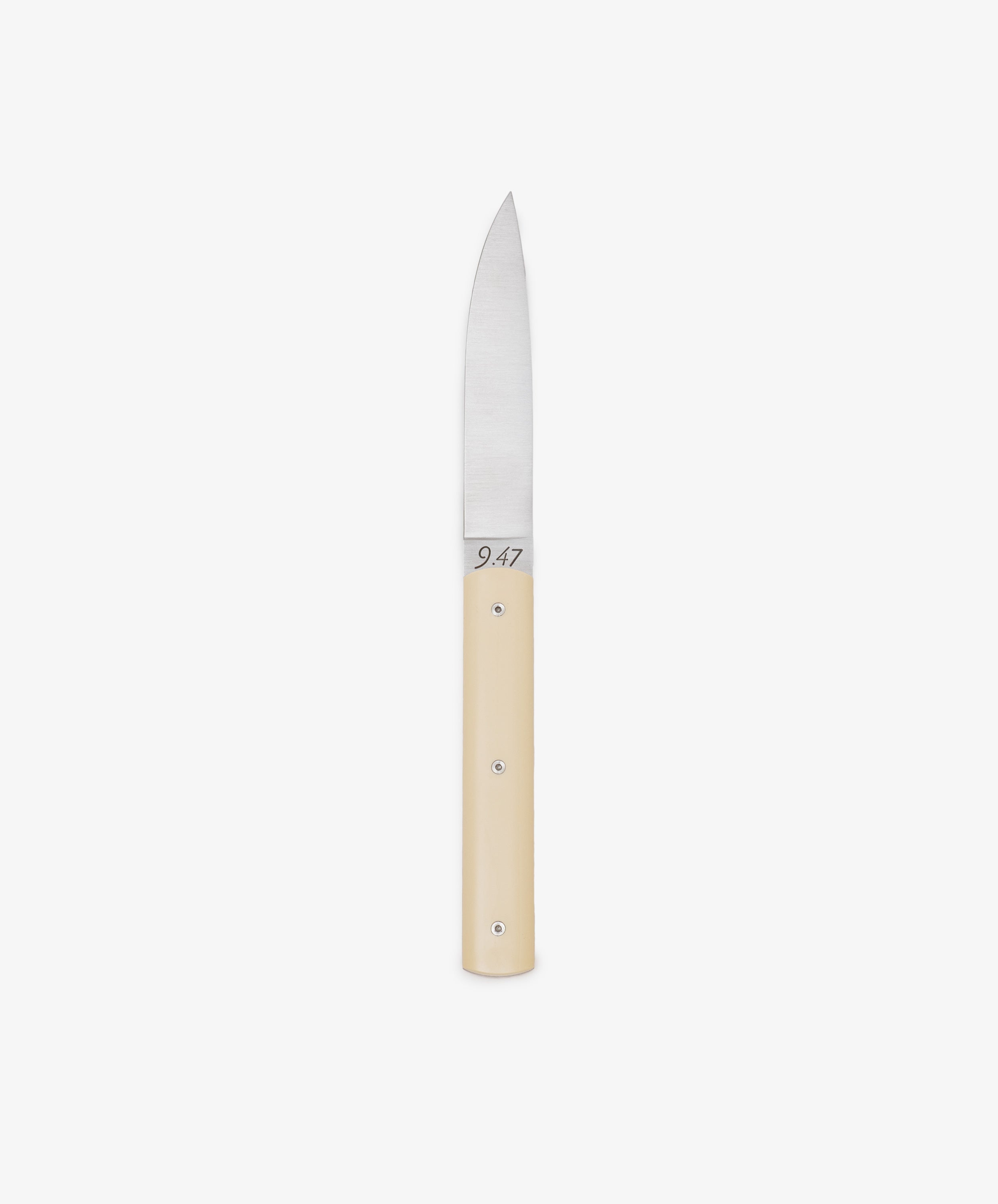 The 9.47 Table Knife features a straight, pointed steel blade and a smooth, light-colored handle, displayed against a white background to highlight its French craftsmanship inspired by the iconic Perceval 9.47.