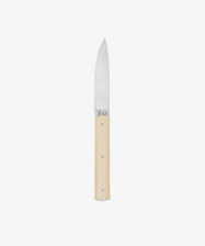 The 9.47 Table Knife features a straight, pointed steel blade and a smooth, light-colored handle, displayed against a white background to highlight its French craftsmanship inspired by the iconic Perceval 9.47.