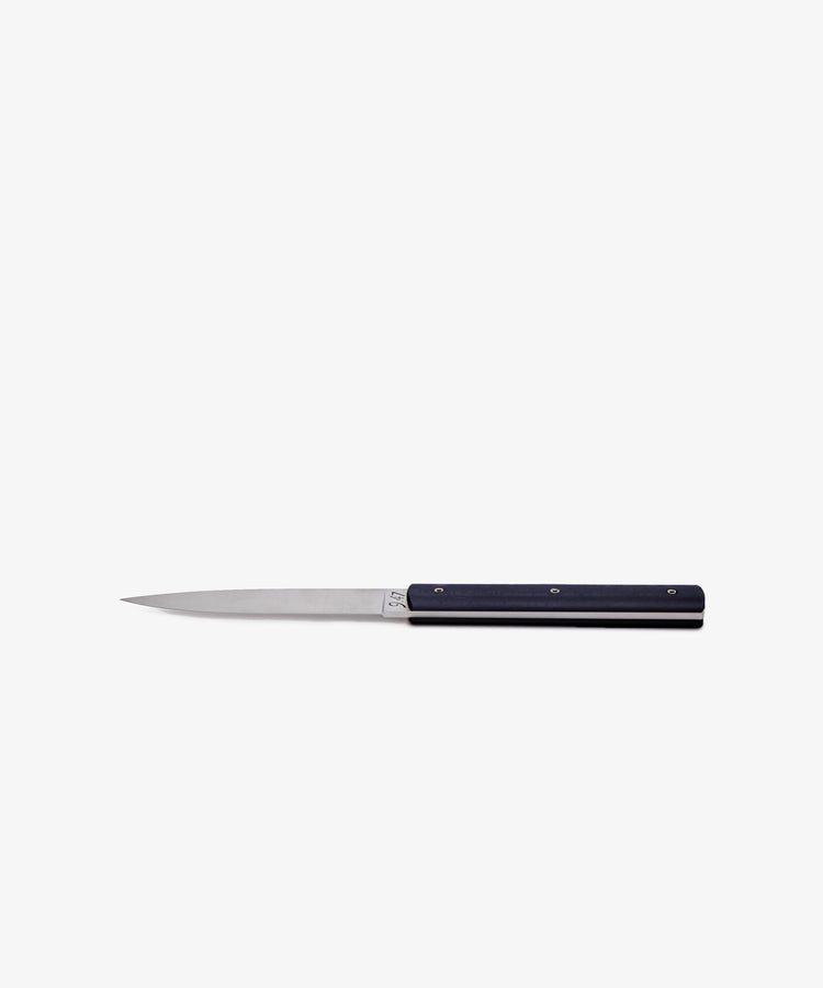 The 9.47 Table Knife, featuring a slim, pointed handmade blade with a straight edge and a black handle, is displayed against a plain white background.