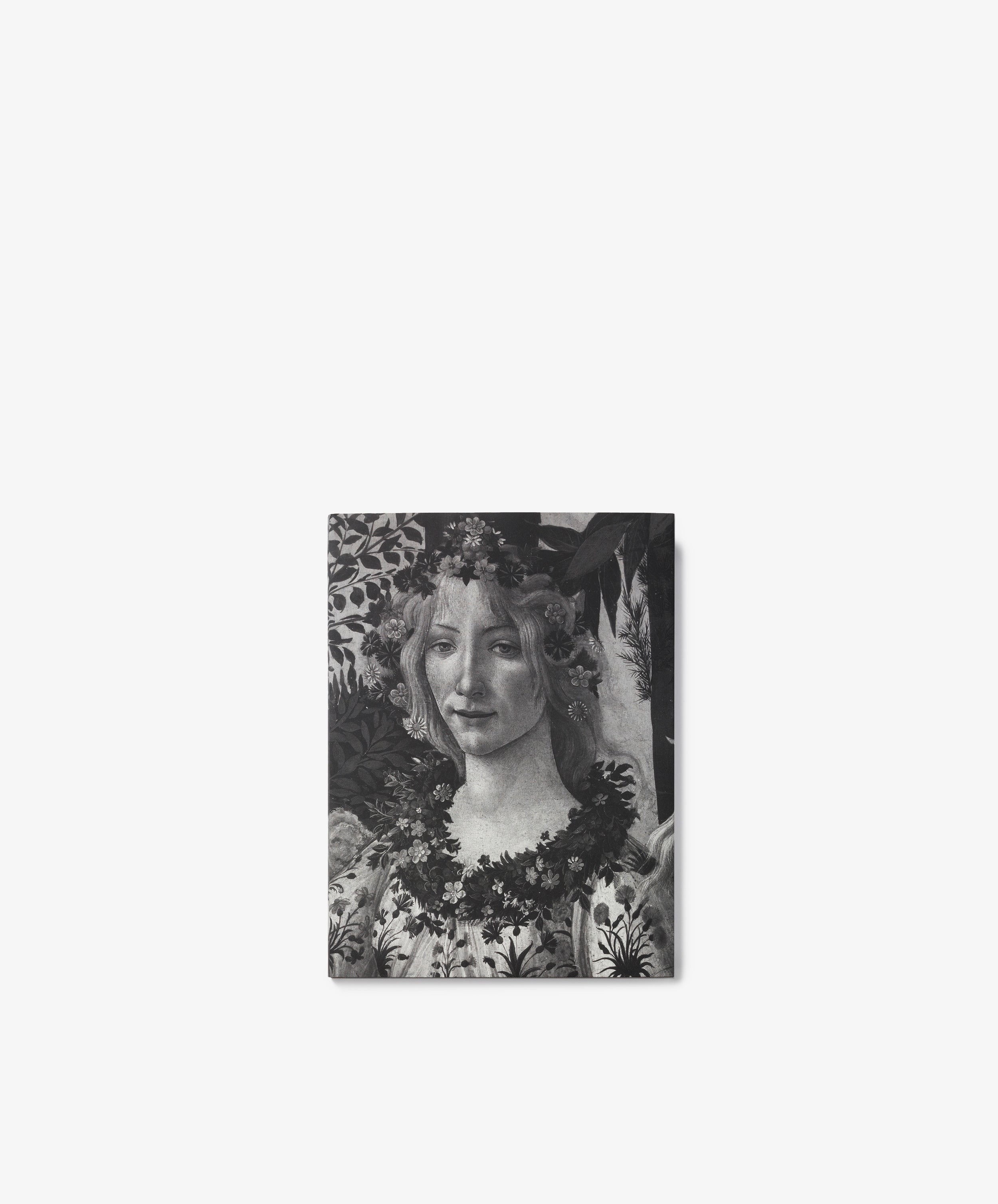 Black and white image of Botticelli, a classical painting reminiscent of Renaissance art, featuring a woman adorned with flowers in her hair and around her neck, set against a leafy background evocative of Primavera.