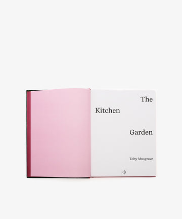 An open book titled The Kitchen Garden, featuring a pink left page and a title page on the right, provides insights into garden history and techniques for growing gardens.