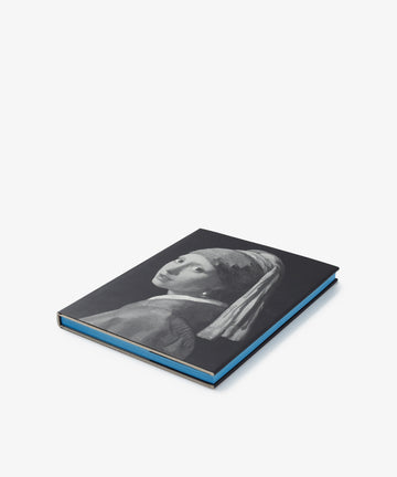 A closed black hardcover art book titled 