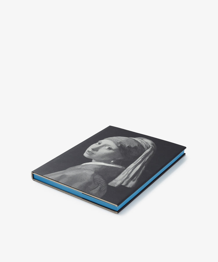 A closed black hardcover art book titled 