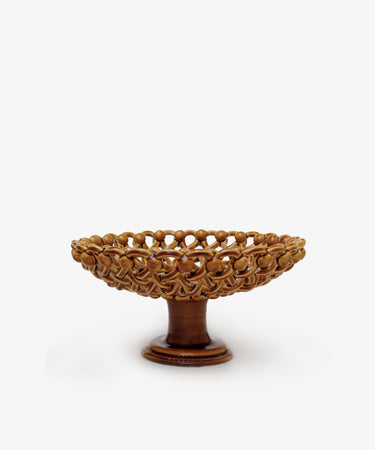 The Remi Footed Bowl features a brown ceramic finish and hand-braided clay lattice sides, creating an elegant sculptural accent against a white background—a standout piece from the decorative fruit bowls collection.