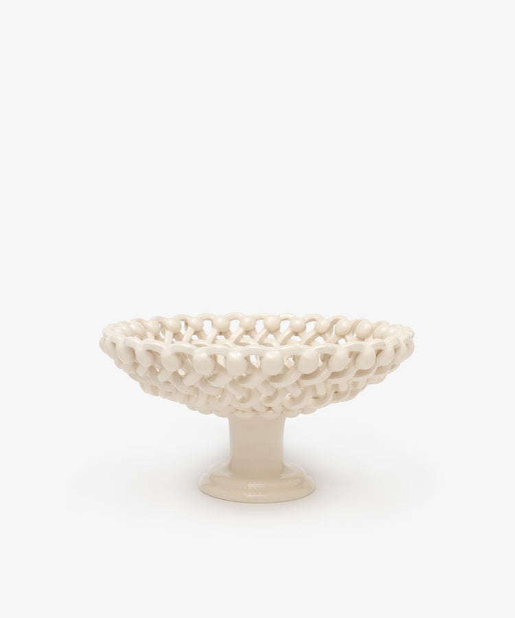 The Remi Footed Bowl features a white ceramic pedestal and open lattice design with hand-braided clay details—an elegant decorative fruit bowl or sculptural accent for any tabletop.