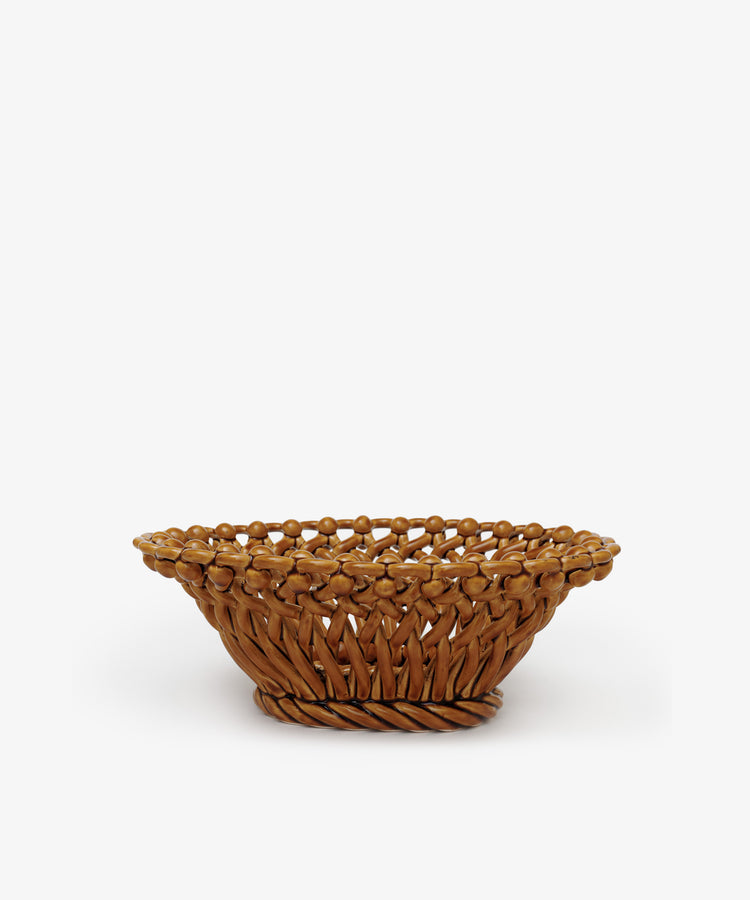 The Remi Decorative Fruit Bowl is a round, shallow basket crafted from brown wicker, shown against a plain white background.