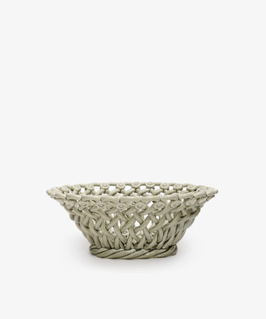 The Remi Decorative Flower Fruit Bowl features a shallow, round ceramic shape with an open lattice design and twisted rope-like rim and base, making it a striking sculptural centerpiece for displaying fruit on any plain white background.