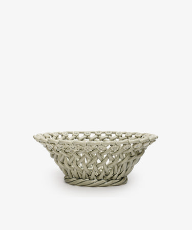 The Remi Decorative Flower Fruit Bowl is a round, light gray ceramic basket with an open-weave design and hand-braided clay craftsmanship, making it a sculptural statement piece perfect for displaying fruit.