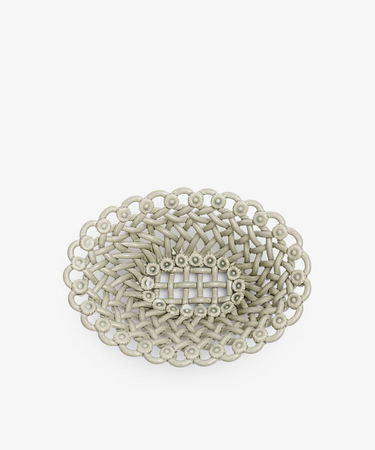 The Remi Decorative Flower Fruit Bowl is an oval-shaped, light gray woven basket with a scalloped edge and sculptural center, perfect as a statement fruit bowl and displayed on a white background.