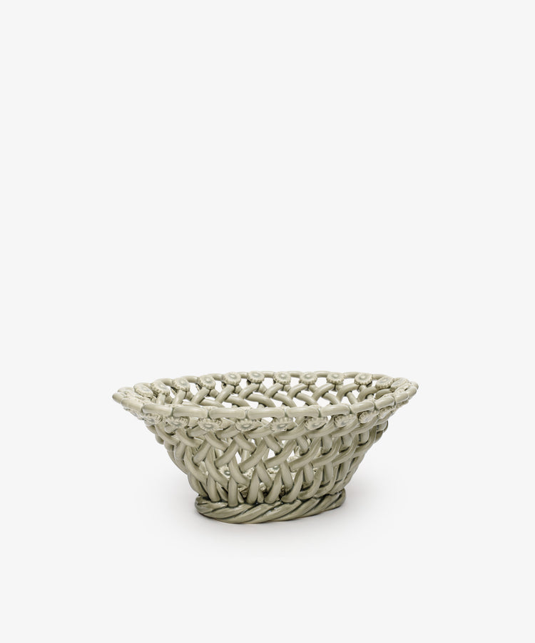 The Remi Decorative Flower Fruit Bowl is a round, shallow basket with a wide opening, crafted from light-colored material and displayed against a plain white background.