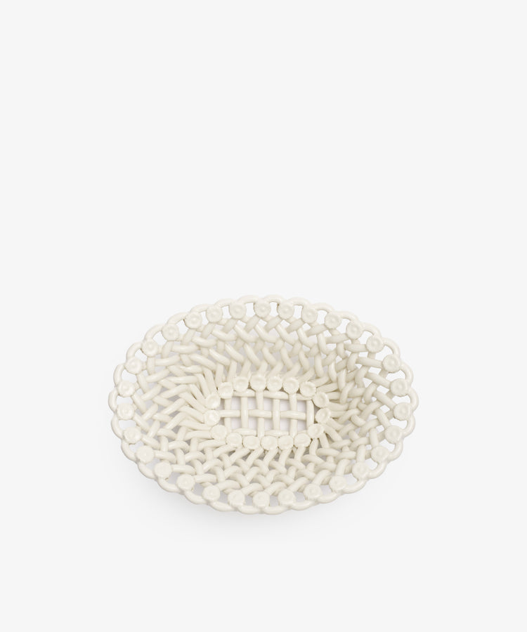 The Remi Decorative Flower Fruit Bowl features an oval-shaped white ceramic build with an open lattice design and decorative rim, making it a sculptural statement piece that adds elegance to any setting.