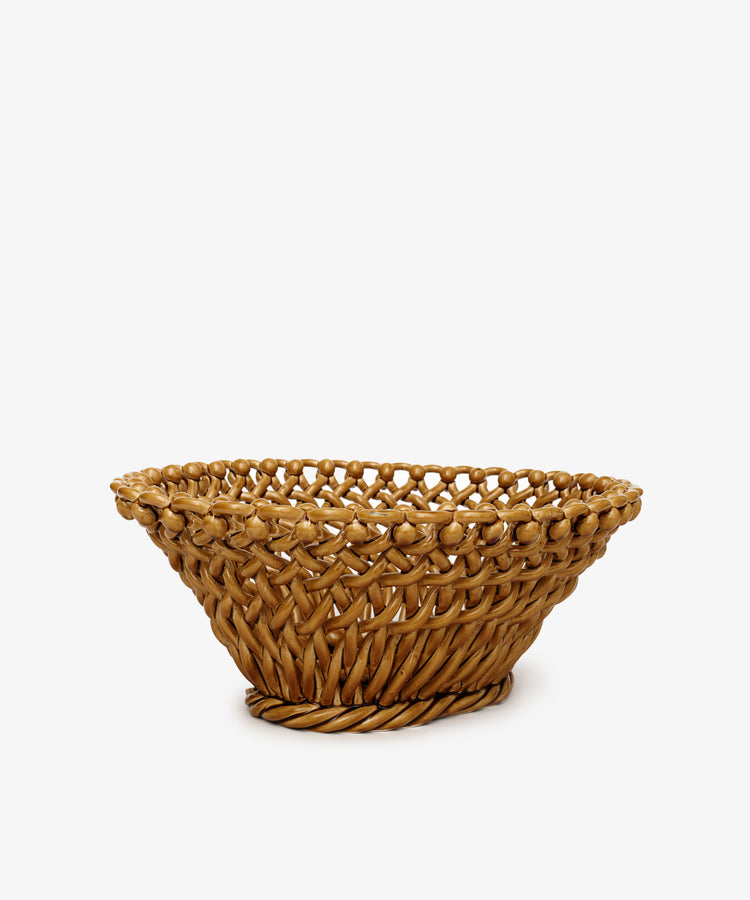 The Remi Decorative Fruit Bowl is a round, woven wicker basket with an open top and slightly flared rim, displayed elegantly against a plain white background.