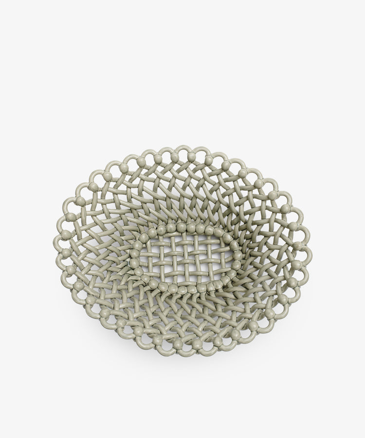 The Remi Decorative Fruit Bowl is a round, shallow woven basket with a lattice pattern and looped edge, perfect for displaying fruit as a stylish centerpiece against a plain white background.