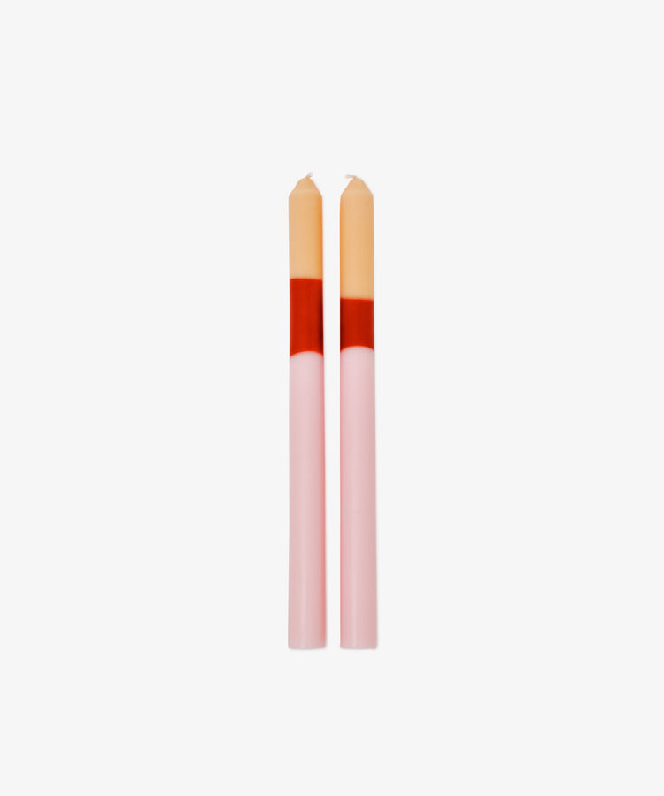 The Deia Candle set features two pink taper sculptural candles with red and beige color blocks at the top, standing side by side against a white background for unique table decor.